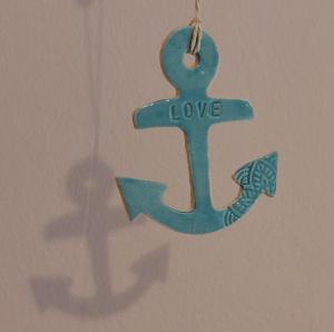 a blue cross with the word love hanging on a wall at "SüdWest" Ferienwohnung in Prerow