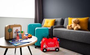 ein Wohnzimmer mit einem Sofa und einem Tisch mit Spielzeug in der Unterkunft Staycity Aparthotels near Disneyland Paris in Bailly-Romainvilliers