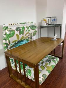 a wooden coffee table with a bench in a room at Sweet Loft Homestay in Johor Bahru