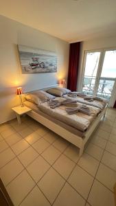 a bedroom with a large bed and a large window at Apartment "OCEANVIEW" in Lubmin