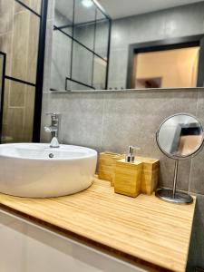a bathroom with a sink and a mirror on a counter at Allegro Home, Apartment by LMG in Sofia