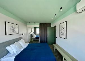 a bedroom with a blue bed and a green door at Old-New Apartment in Central Kaunas in Kaunas