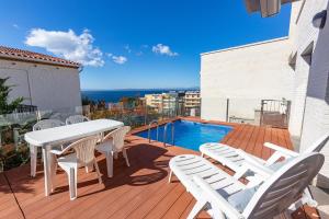 een terras met een tafel en stoelen en een zwembad bij RNET - Casa 4 - Vista Mar Almadrava Roses in Roses
