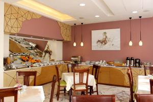 un ristorante con tavolo, sedie e cucina di Europe Hotel a Yerevan