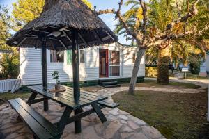 a picnic table with an umbrella in front of a house at Camping & Resort La Torre del Sol in Montroig