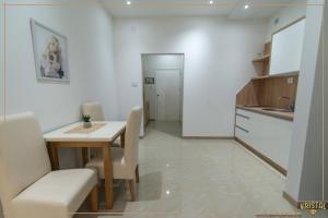 a kitchen and dining room with a table and chairs at Kristal Apartmani - Banja Ždrelo in Ždrelo