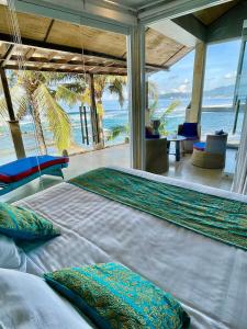 a bedroom with a bed with a view of the ocean at Ocean Suite - Exceptional Beachfront Apartment - Candidasa in Candidasa