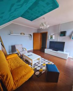 een woonkamer met een bank en een tafel bij Nosen Apartment in Bistriţa