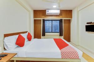 Un dormitorio con una cama con almohadas rojas y una ventana en Chaitanya Near Fun Time Multiplex, en Yerandwane