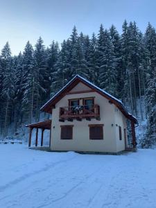 una casa nella neve di fronte a una foresta di Chata Mošnica a Lazisko