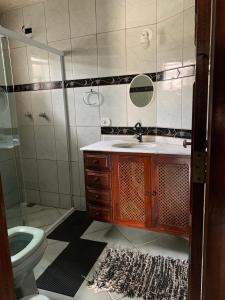 La salle de bains est pourvue d'un lavabo, de toilettes et d'un miroir. dans l'établissement Hostel 420, à Parati