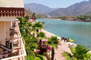 a view of a beach with palm trees and a body of water at Yog Niketan By Sanskriti in Rishīkesh