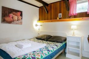 a bedroom with a bed and a table with a lamp at Vakantiehuis De Koeboet - Callantsoog in Callantsoog