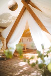 a tent with a bed in a room at Kabaceira Glamping in Atalaia