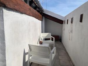Un balcón con 2 sillas blancas y una mesa. en Rest Valencia, en Valencia