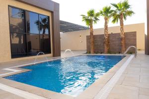 una piscina con palmeras frente a un edificio en بيرفيلا, en Al Rass