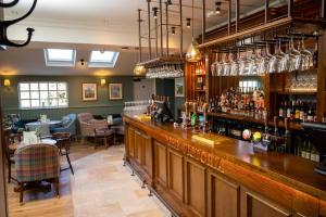 a bar in a restaurant with a counter and chairs at Victoria Hotel by Chef & Brewer Collection in Menai Bridge