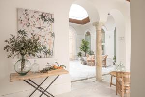 una sala de estar con una mesa con un jarrón de flores en Mylu Suites by Puerta Catedral en Sevilla