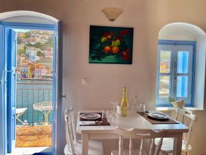 a dining room with a table and a painting on the wall at Nikolakis, Seafront - Harbor view in Symi