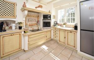 a large kitchen with wooden cabinets and stainless steel appliances at Cozy Home In Méjannes-Lès-Alès in Méjannes-lès-Alès
