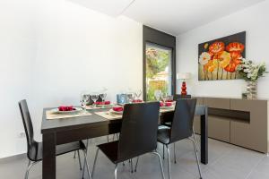 羅薩斯的住宿－RNET - Casa 4 - Vista Mar Almadrava Roses，一间用餐室,配有黑色的桌子和椅子