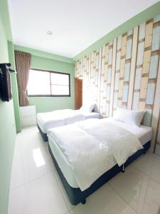 um quarto com 2 camas e uma janela em 108 House Inn em Tainan