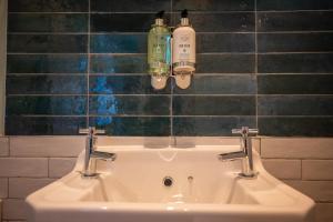 a bathroom sink with two bottles on the wall at Victoria Hotel by Chef & Brewer Collection in Menai Bridge