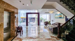 a lobby of a building with a staircase and a living room at Xavia Hotel Quy Nhơn in Quy Nhon