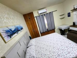 Dormitorio pequeño con cama y lavamanos en Apartamento único na praia do Farol de Itapuã, en Salvador