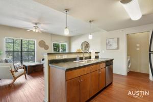 cocina con fregadero y sala de estar. en Fully Equipped w Stylish Design and Free Parking, en Austin