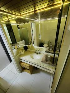 a bathroom with a sink and a mirror at Apartamento único na praia do Farol de Itapuã in Salvador