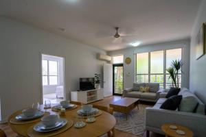 a living room with a couch and a table at Nightcliff Retreat: Stylish 2BR Apt Near Foreshore in Nightcliff