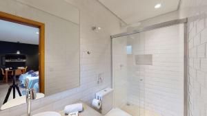 a bathroom with a shower and a sink and a mirror at Studio 4 Pinheiros by Oba in São Paulo