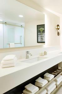 a white bathroom with a sink and a mirror at Renaissance St. Louis Airport Hotel in Saint Louis
