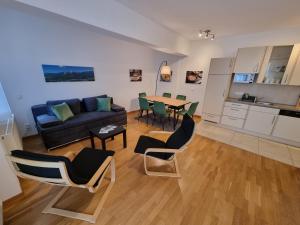 City Appartements Villach في فيلاخ: غرفة معيشة مع أريكة وطاولة وكراسي