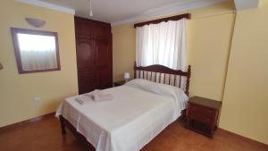 a bedroom with a white bed and a window at Apartamento acolhedor com vista para o Monte Cara in Mindelo