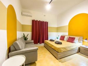 um quarto com uma cama, um sofá e uma cadeira em Cozy 1 bedroom apartment in Gzira 4 em Il-Gżira
