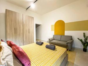 um quarto com uma cama, uma cadeira e um sofá em Cozy 1 bedroom apartment in Gzira 4 em Il-Gżira