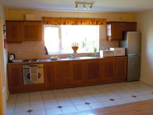 a kitchen with a sink and a refrigerator and a window at 29 Waterville Links Holiday Home in Waterville