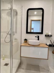 a bathroom with a sink and a shower and a mirror at Appt Vue Mer Exceptionnelle Triple Expo - 70m 2ch - Rénové in Saint-Cast-le-Guildo