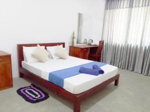 a bedroom with a bed with a blue towel on it at Savendro in Hikkaduwa