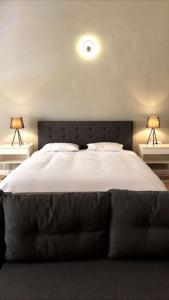 a bedroom with a large bed with two lamps at Townhouse with dreamy terrace in Valletta