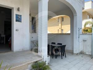 eine Terrasse mit einem schwarzen Tisch und Stühlen in der Unterkunft Villino Mediterraneo n°1 in Porto Cesareo