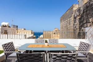 a table and chairs on a patio with a view of the ocean at Townhouse with dreamy terrace in Valletta