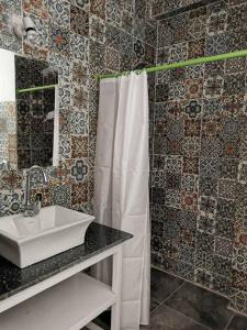 a bathroom with a sink and a white shower curtain at Bayt Al Jabal luxor in Luxor