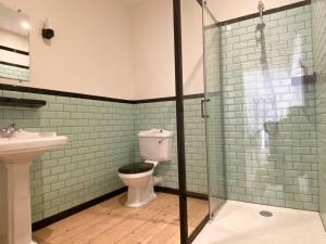 La salle de bains est pourvue de toilettes et d'une douche en verre. dans l'établissement L’appartement 39, à Lons-le-Saunier