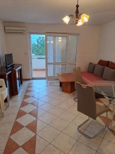salon z kanapą i stołem w obiekcie Apartman zarok w Bašce