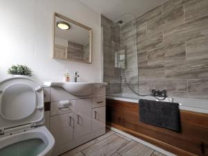 Un baño con inodoro, lavabo y ducha. en Historic cottage next to loch lomond Luss, en Alexandria 26 fotos más