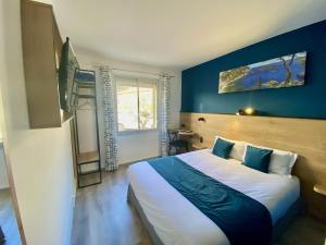 ein Schlafzimmer mit einem großen Bett mit blauer Wand in der Unterkunft The Originals City, Hôtel Azur, Fos-sur-Mer in Fos-sur-Mer