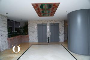 eine Lobby mit zwei grauen Türen und einer Ziegelwand in der Unterkunft HOLIDAY VISTA MAR II in Oropesa del Mar